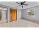 Bright bedroom featuring a ceiling fan, light wood floors, closet, and hall doorway at 800 Black Duck Dr, Port Orange, FL 32127