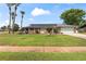 Charming single-story home with solar panels, a well-kept lawn, and mature palm trees enhancing curb appeal at 800 Black Duck Dr, Port Orange, FL 32127
