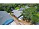 An aerial view of a cozy pink single-Gathering home with gray roof nestled amongst lush greenery with new driveway at 805 E 18Th Ave, New Smyrna Beach, FL 32169