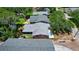 An aerial view of a cozy pink single-Gathering home with gray roof nestled amongst lush greenery with new driveway at 805 E 18Th Ave, New Smyrna Beach, FL 32169