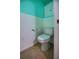 Cozy half-bathroom with white toilet and wainscoting and bright turquoise walls at 805 E 18Th Ave, New Smyrna Beach, FL 32169