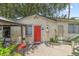 A cozy patio area with an outdoor dining set, adjacent to a charming home with a striking red door at 807 Craig St, New Smyrna Beach, FL 32168