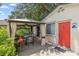 Backyard patio featuring a dining set in gazebo, next to a home with a vibrant red door and lush foliage at 807 Craig St, New Smyrna Beach, FL 32168