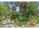 Lush backyard featuring a serene pond with vibrant greenery and tropical trees, creating a relaxing oasis at 807 Craig St, New Smyrna Beach, FL 32168