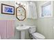 Classic bathroom has pedestal sink, patterned wallpaper, and updated lighting at 807 Craig St, New Smyrna Beach, FL 32168