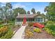 Inviting exterior showcasing a quaint home with a red bridge, lush landscaping, and charming architectural details at 807 Craig St, New Smyrna Beach, FL 32168
