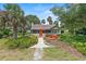 Charming home featuring a bright orange door and a delightful red bridge in its landscaped front yard at 807 Craig St, New Smyrna Beach, FL 32168