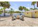 Outdoor fire pit with seating offers a relaxing space surrounded by palm trees at 821 Ocean Ave, New Smyrna Beach, FL 32169