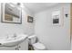 Charming bathroom featuring a toilet, sink, vanity, and a framed mirror over wainscoting at 821 Ocean Ave, New Smyrna Beach, FL 32169