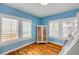 Sunny bedroom with hardwood floors, blue walls, shuttered windows, and unique bunk-bed/wardrobe combination at 821 Ocean Ave, New Smyrna Beach, FL 32169