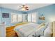 Serene bedroom features bright blue walls, hardwood floors, shuttered windows, and comfy, patterned bedding at 821 Ocean Ave, New Smyrna Beach, FL 32169