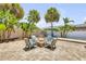 Charming backyard firepit area with four chairs and tropical landscaping for outdoor enjoyment at 821 Ocean Ave, New Smyrna Beach, FL 32169