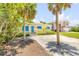 Charming yellow beach house with blue shutters, surrounded by lush greenery and palm trees at 821 Ocean Ave, New Smyrna Beach, FL 32169