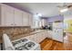 Charming kitchen featuring wooden floors, white cabinets, and modern appliances at 821 Ocean Ave, New Smyrna Beach, FL 32169