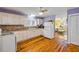 Cozy kitchen with wooden floors, white appliances and cabinets, and a view into the living room at 821 Ocean Ave, New Smyrna Beach, FL 32169