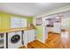 Functional laundry room featuring a washer/dryer combo, built-in cabinets, and seamless transition to kitchen at 821 Ocean Ave, New Smyrna Beach, FL 32169