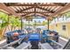 Inviting covered patio with comfortable seating, a ceiling fan, and views of lush tropical landscaping at 821 Ocean Ave, New Smyrna Beach, FL 32169