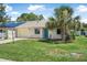 Inviting single-story home featuring solar panels, a palm tree, and well-kept lawn at 837 Acorn Ln, Port Orange, FL 32127