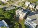 Aerial view of the house, with deck, rooftop deck, surrounding foliage, and adjacent houses at 895 Catfish Ave, New Smyrna Beach, FL 32169