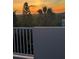 Picturesque sunset view over lush greenery from the balcony with a white railing at 895 Catfish Ave, New Smyrna Beach, FL 32169