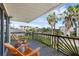 Relaxing balcony with two wooden chairs overlooking lush landscaping and partial ocean views at 895 Catfish Ave, New Smyrna Beach, FL 32169