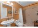 Bright orange bathroom featuring a sink, toilet, and tiled shower with a shower curtain for privacy at 895 Catfish Ave, New Smyrna Beach, FL 32169