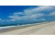 Expansive beach view with blue sky, gentle waves, and soft sand, perfect for relaxation and coastal enjoyment at 895 Catfish Ave, New Smyrna Beach, FL 32169