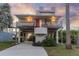 Unique stilt home with a charming red door, spacious driveway, and lush tropical landscaping at 895 Catfish Ave, New Smyrna Beach, FL 32169
