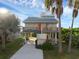 Coastal house on stilts features a drive, yard, green shrubs, and a wrap-around porch at 895 Catfish Ave, New Smyrna Beach, FL 32169