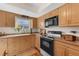 Well-lit kitchen boasting wooden cabinets, an electric range, and stone countertops at 895 Catfish Ave, New Smyrna Beach, FL 32169