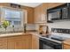 Functional kitchen with wood cabinets, stone counters and modern appliances at 895 Catfish Ave, New Smyrna Beach, FL 32169