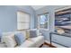 Cozy living room with blue walls, natural light, and comfortable white sofa with patterned pillows at 895 Catfish Ave, New Smyrna Beach, FL 32169