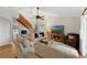Bright living room featuring a vaulted ceiling, a wooden staircase, and comfortable seating with a TV at 895 Catfish Ave, New Smyrna Beach, FL 32169
