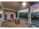 Covered patio with rocking chairs and shell planter, shed with red door and pea gravel base at 895 Catfish Ave, New Smyrna Beach, FL 32169