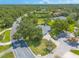 Expansive aerial view of home with a large yard, mature trees, and beautiful landscaping on a well-maintained street at 904 Clubhouse Blvd, New Smyrna Beach, FL 32168