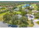 Aerial view of the property with a well manicured lawn near a golf course, lake, and mature shade trees at 904 Clubhouse Blvd, New Smyrna Beach, FL 32168