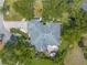 Overhead view of home's roof, patio, mature trees, manicured landscape, and circular driveway showcasing property features at 904 Clubhouse Blvd, New Smyrna Beach, FL 32168