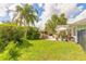 Landscaped backyard with brick patio and seating, surrounded by lush greenery at 904 Clubhouse Blvd, New Smyrna Beach, FL 32168