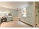 Bright bathroom featuring an elegant chandelier, vanity, bathtub, and glass shower enclosure at 904 Clubhouse Blvd, New Smyrna Beach, FL 32168