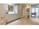 Bathroom featuring neutral tile, double sinks, a shower, and a view into the bedroom beyond at 904 Clubhouse Blvd, New Smyrna Beach, FL 32168