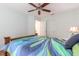 Comfortable bedroom with a ceiling fan, natural light, and decorative bedding at 904 Clubhouse Blvd, New Smyrna Beach, FL 32168