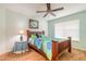 Bedroom featuring wood-look floors, a ceiling fan, a wood-frame bed, and a large window at 904 Clubhouse Blvd, New Smyrna Beach, FL 32168