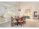 Open dining room with unique wall art, vaulted ceilings, and bright windows with plantation shutters at 904 Clubhouse Blvd, New Smyrna Beach, FL 32168