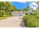 Home exterior featuring a long driveway leading to a two-car garage with vibrant landscaping at 904 Clubhouse Blvd, New Smyrna Beach, FL 32168