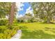 Charming home with light blue facade, surrounded by a lush green lawn and mature trees at 904 Clubhouse Blvd, New Smyrna Beach, FL 32168
