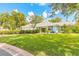 Charming home featuring a well-manicured lawn, lush landscaping, and a light blue exterior at 904 Clubhouse Blvd, New Smyrna Beach, FL 32168