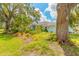Light blue exterior home featuring a beautifully landscaped front yard with mature trees and plants at 904 Clubhouse Blvd, New Smyrna Beach, FL 32168