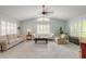 Bright living room with vaulted ceiling, plantation shutters, and neutral tile flooring at 904 Clubhouse Blvd, New Smyrna Beach, FL 32168
