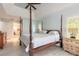 Inviting bedroom with four-poster bed, complemented by natural light and ensuite access at 904 Clubhouse Blvd, New Smyrna Beach, FL 32168