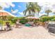 Outdoor brick patio featuring multiple seating areas with umbrellas and a grill area at 904 Clubhouse Blvd, New Smyrna Beach, FL 32168